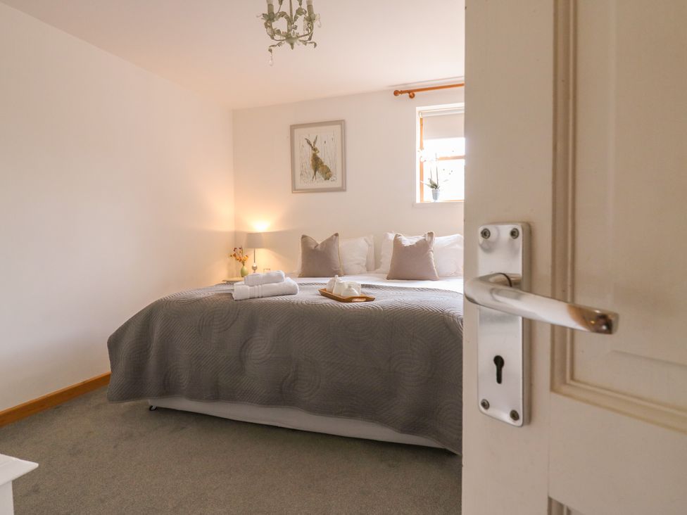 A bedroom with a bed and a lamp at BB House Roxhill Manor Farm
