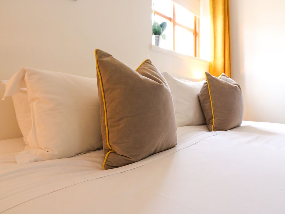 A bed with pillows against a window at BB House Roxhill Manor Farm