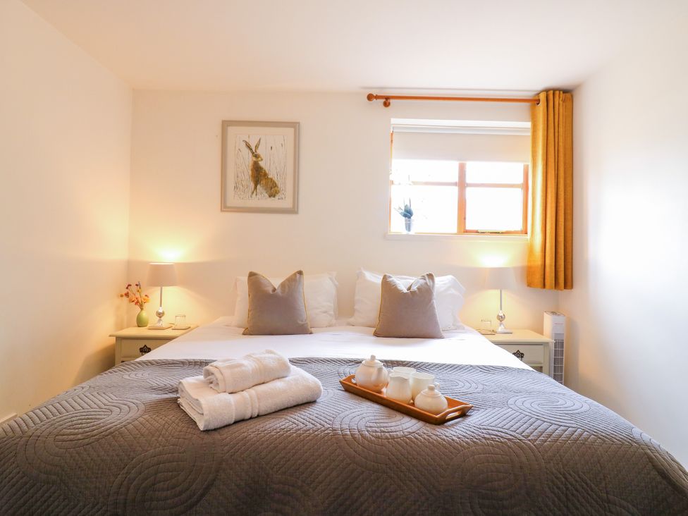 A bedroom with a bed and side table at BB House Roxhill Manor Farm