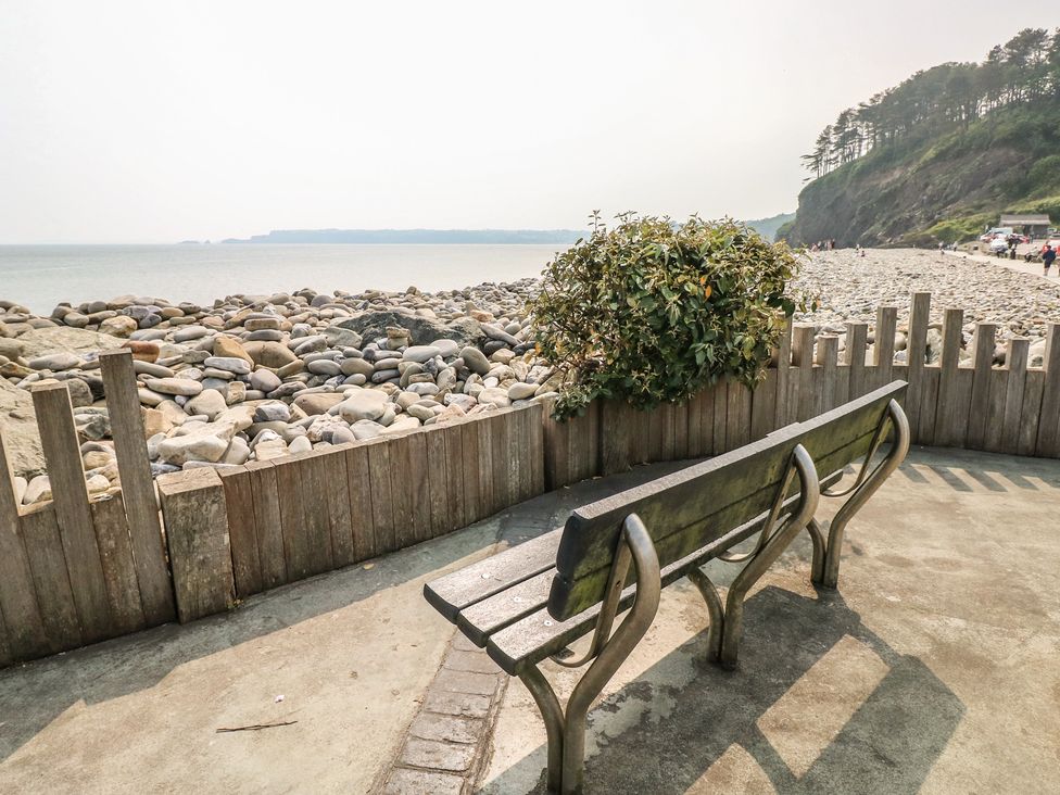 A bench overlooking the sea and rocks at Stable Cottage, Narberth near Templeton