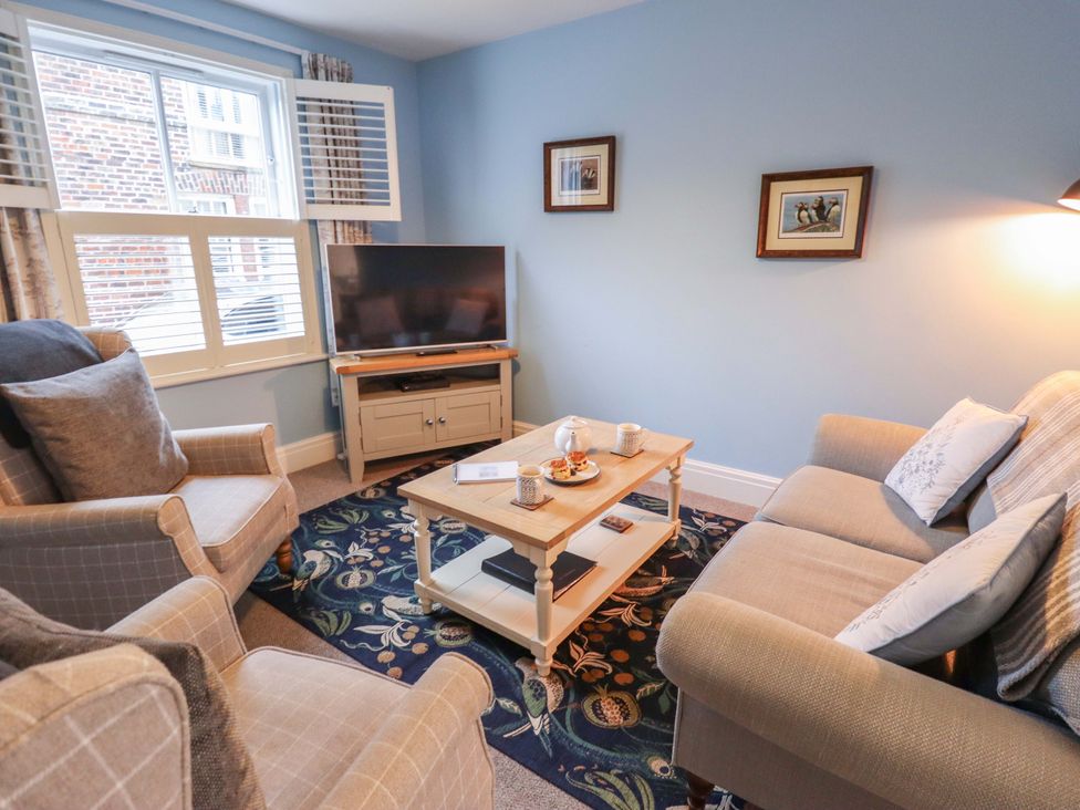 A living room with a sofa and armchair at Armstrong Cottage Beverley