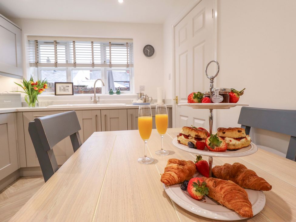 A kitchen with a dining table and food items at Armstrong Cottage Beverley