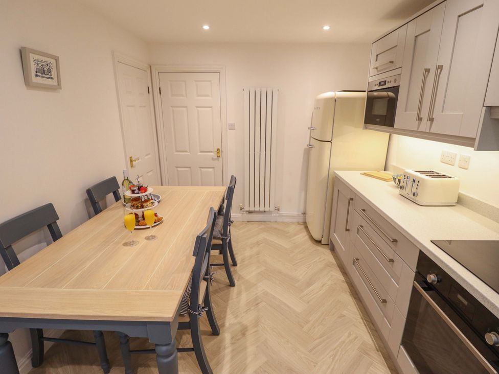 A kitchen with a dining table and chairs at Armstrong Cottage in Beverley