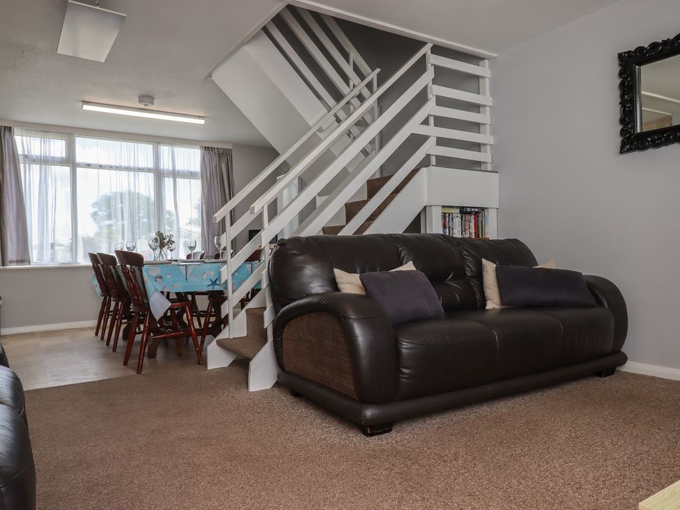 A living room with a sofa and dining area at Turtle Chalet in Dawlish Warren