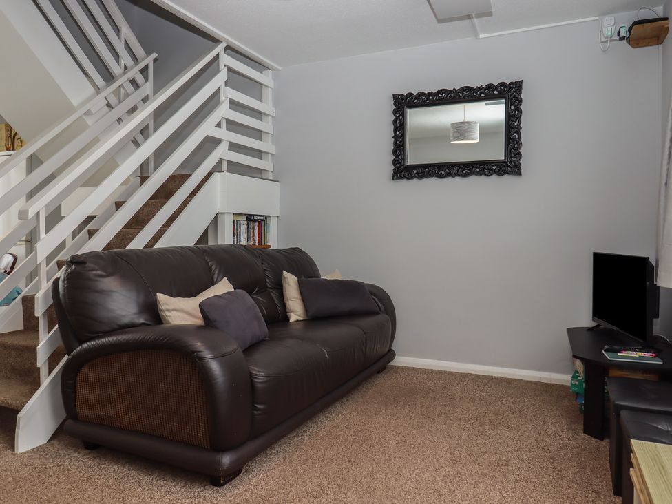 A living room with a sofa and mirror at Turtle Chalet in Dawlish Warren