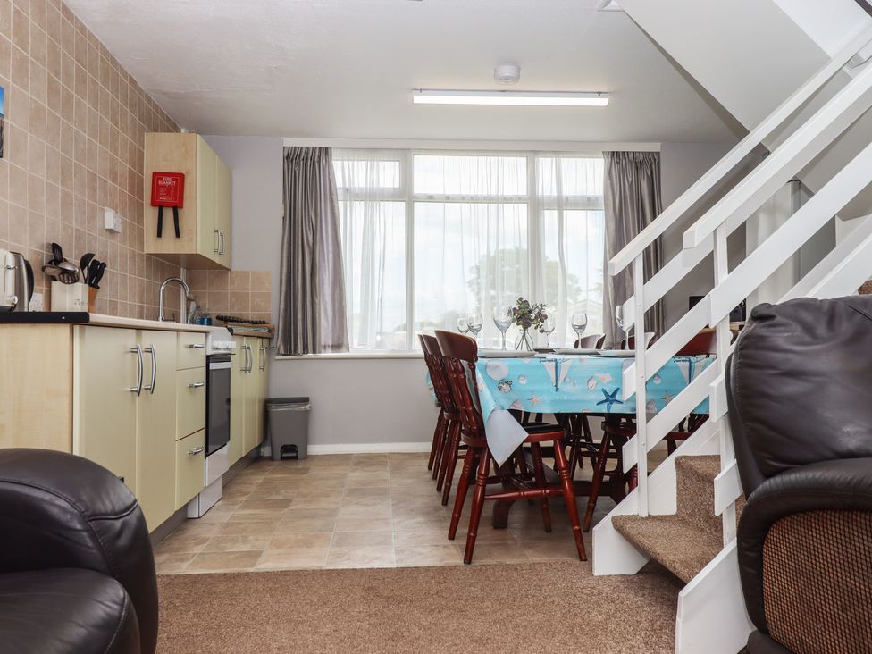 A kitchen with a table and chairs at Turtle Chalet in Dawlish Warren