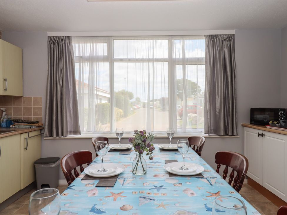 A dining room with a table set for a meal at Turtle Chalet in Dawlish Warren