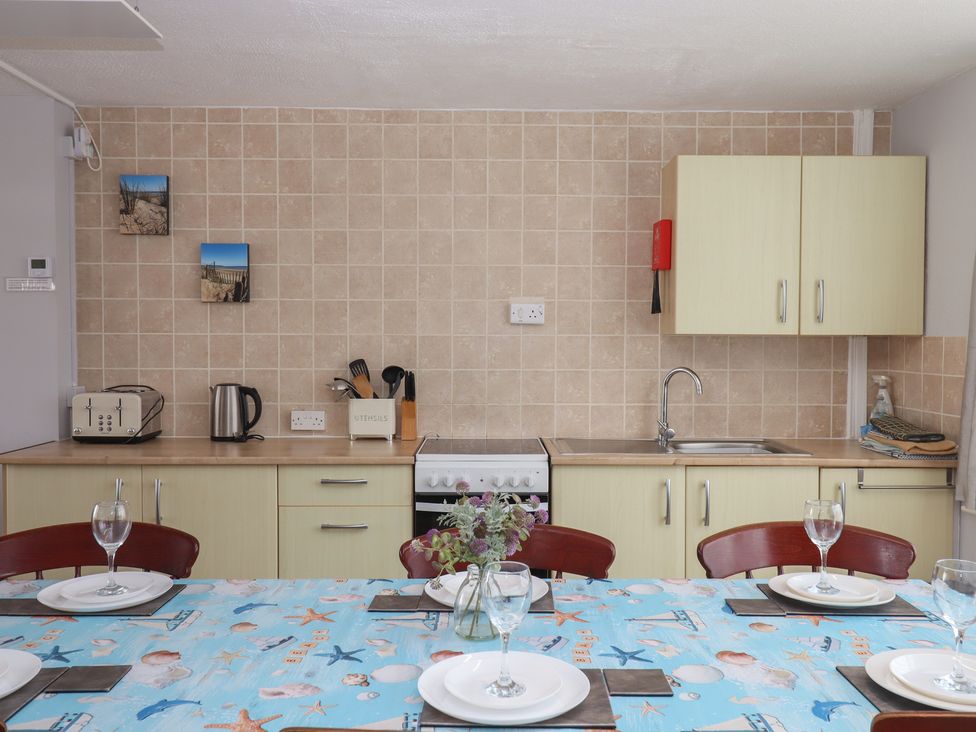 A kitchen with dining table and utensils at Turtle Chalet in Dawlish Warren