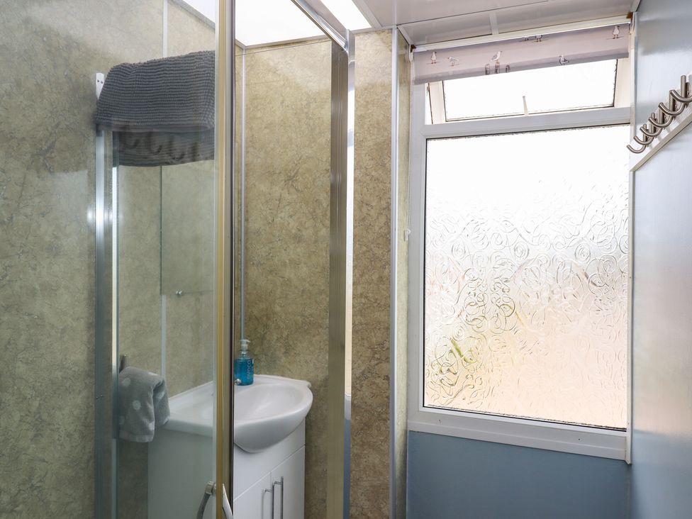 A bathroom with a shower and wash basin at Turtle Chalet in Dawlish Warren