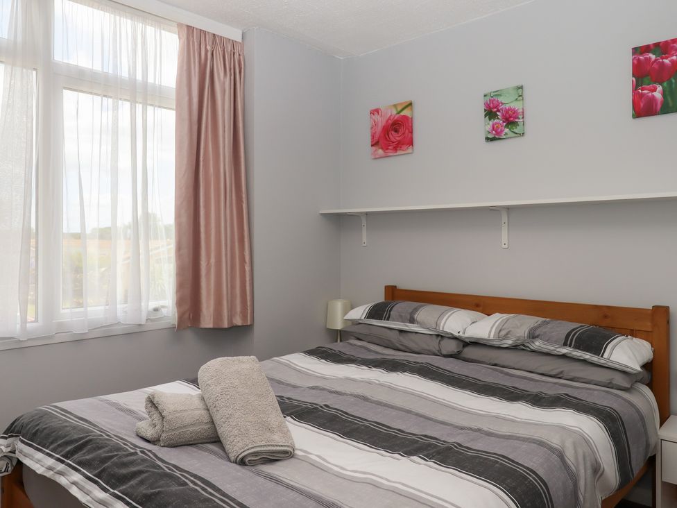 A bedroom with a bed and window at Turtle Chalet in Dawlish Warren