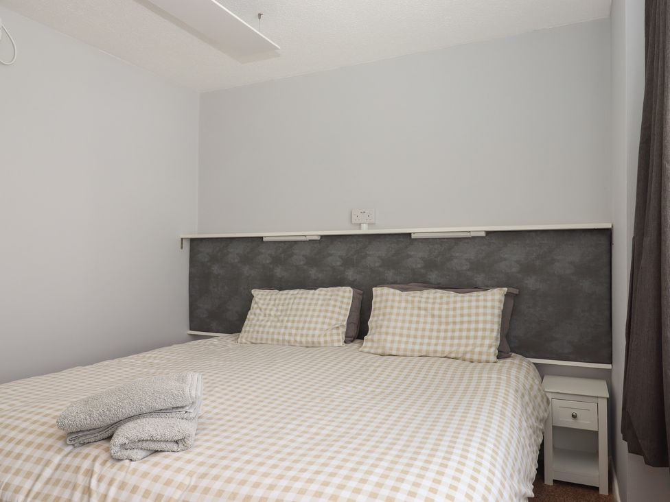 A bedroom with bed and towels at Turtle Chalet in Dawlish Warren