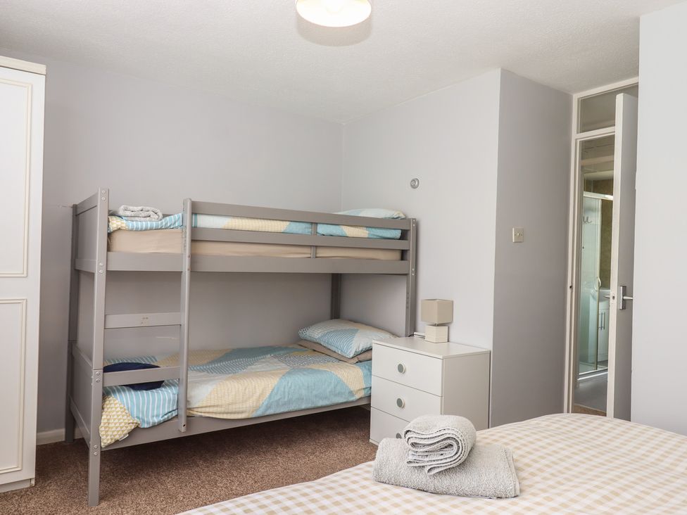 A bedroom with a bunk bed and a bedside table at Turtle Chalet in Dawlish Warren