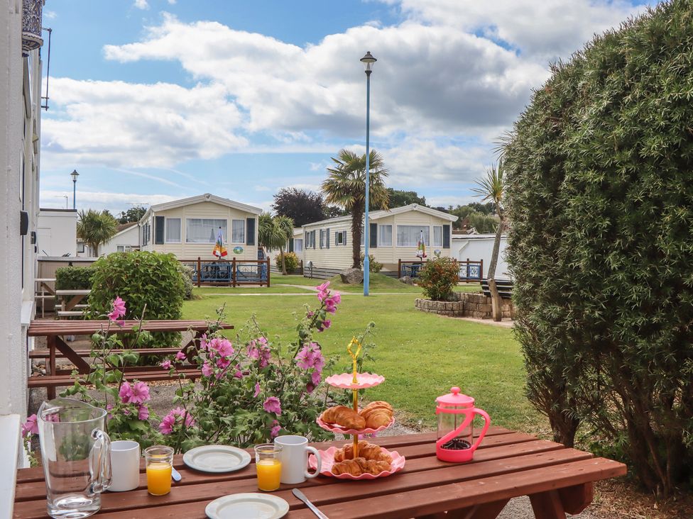 A garden with tables and croissants at Turtle Chalet in Dawlish Warren