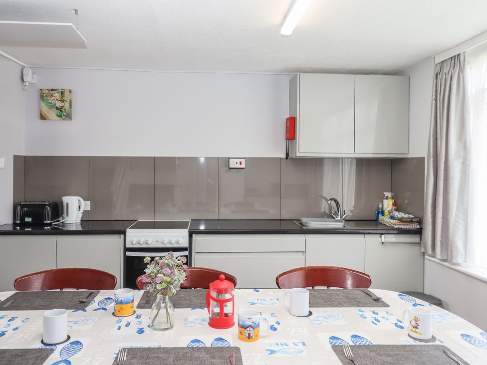 A kitchen with appliances and a dining table at Dolphin Chalet in Dawlish Warren