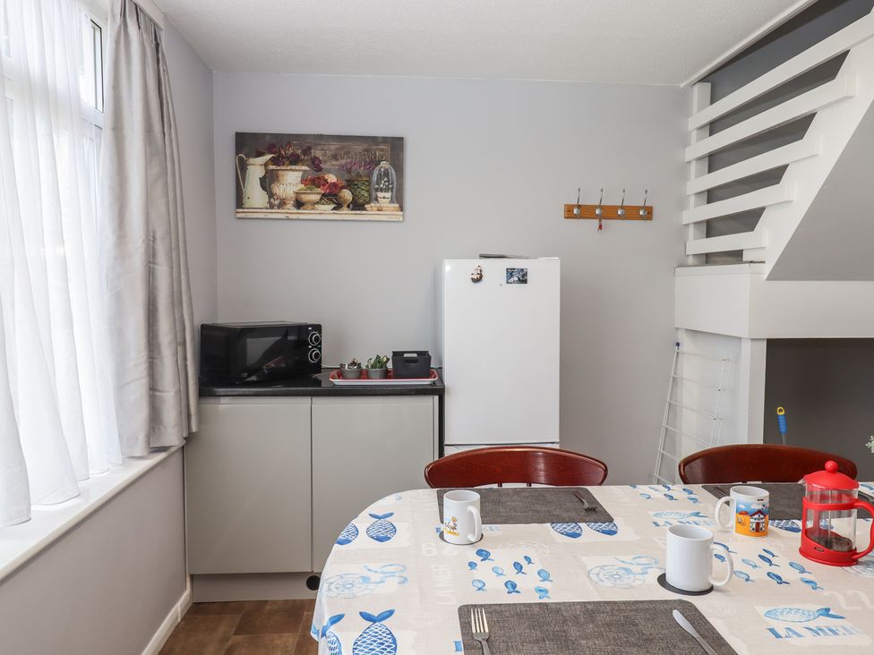 A kitchen with a table and chairs at Dolphin Chalet in Dawlish Warren