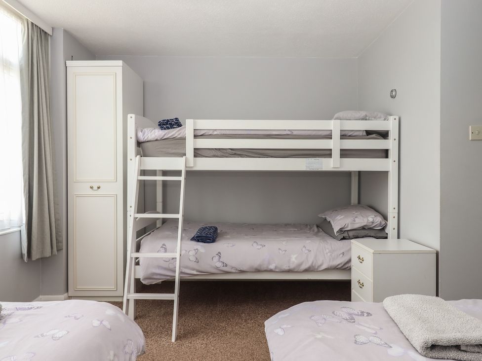 A bedroom with a bunk bed and a wardrobe at Dolphin Chalet Dawlish Warren
