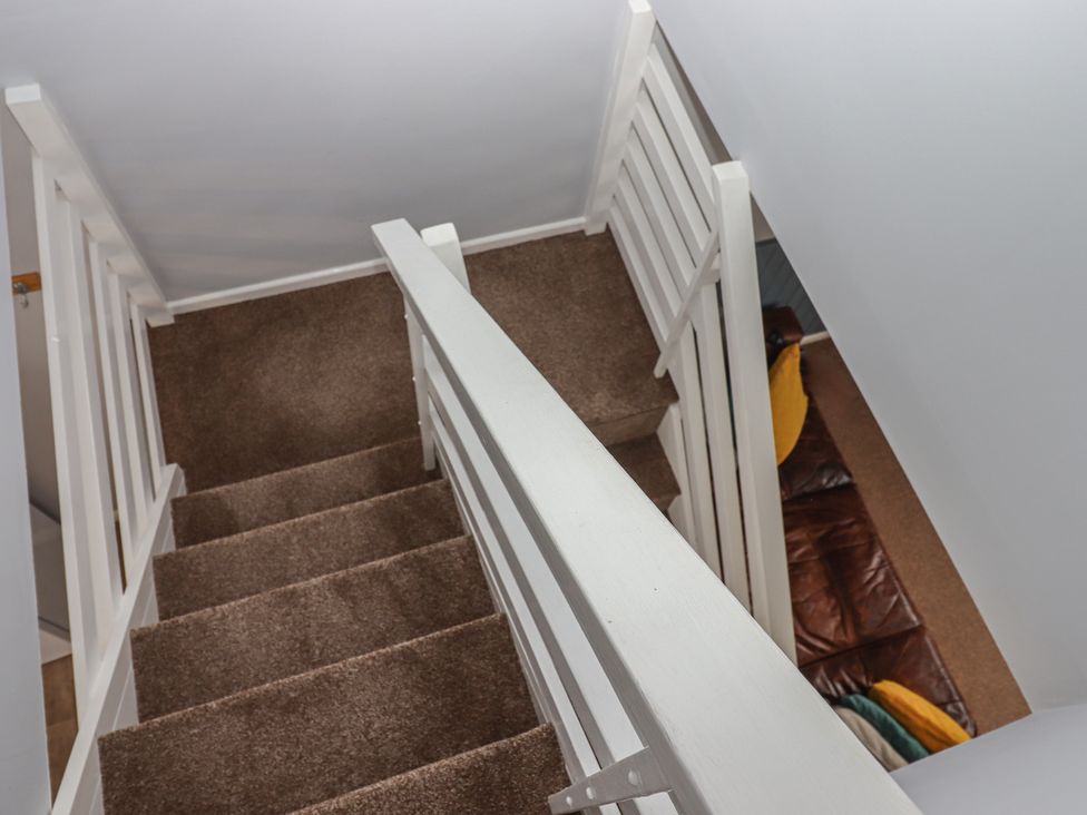 A stairwell with carpeted stairs and handrail at Dolphin Chalet Dawlish Warren