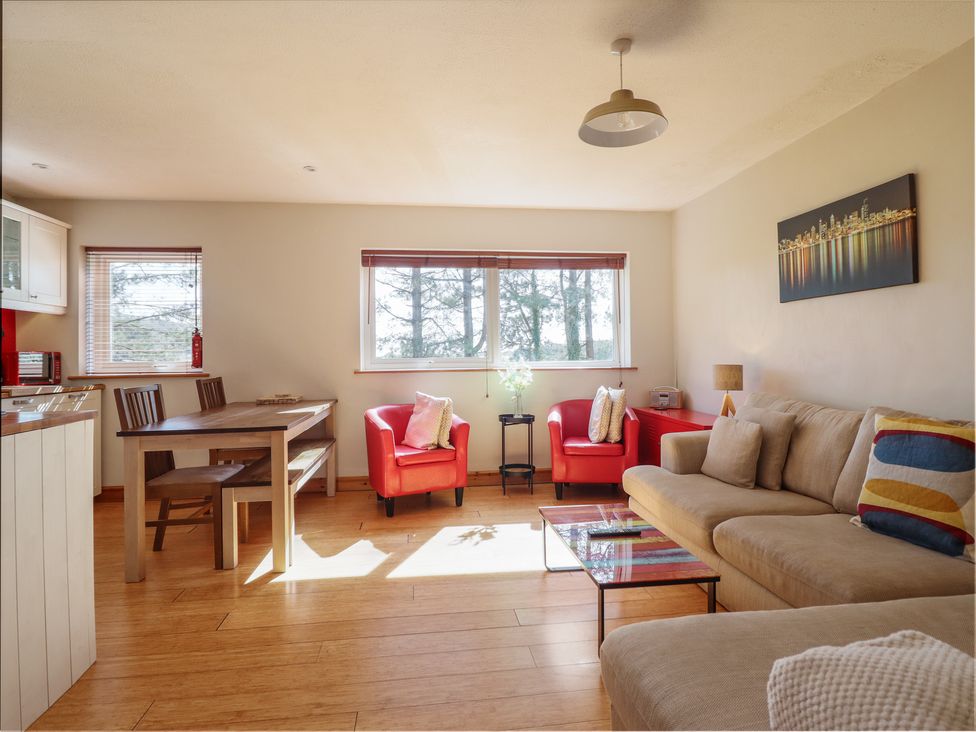 A living room with a sofa and dining area at Redwood in Harlech