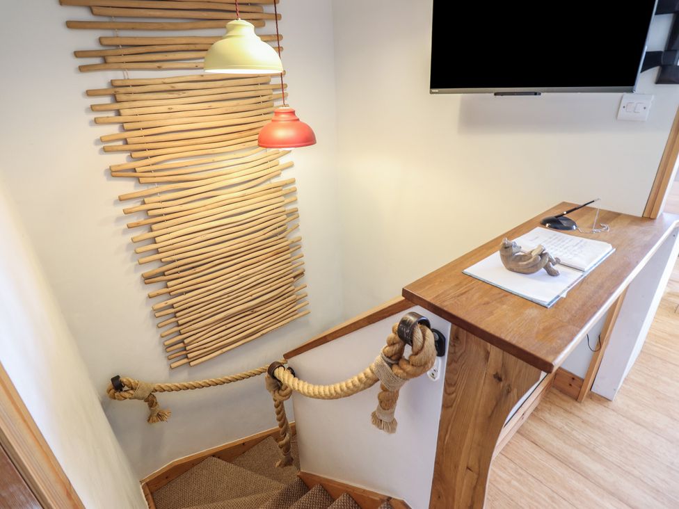 A staircase with a wall decor and desk at Redwood in Harlech
