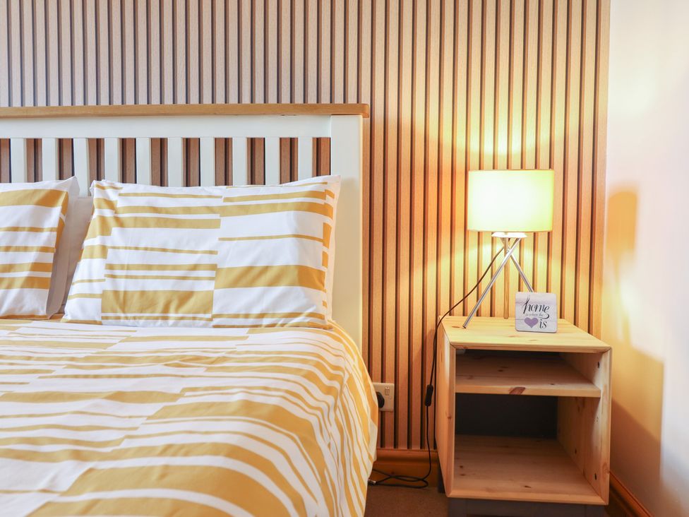 A bedroom with a bed and bedside lamp at Redwood in Harlech