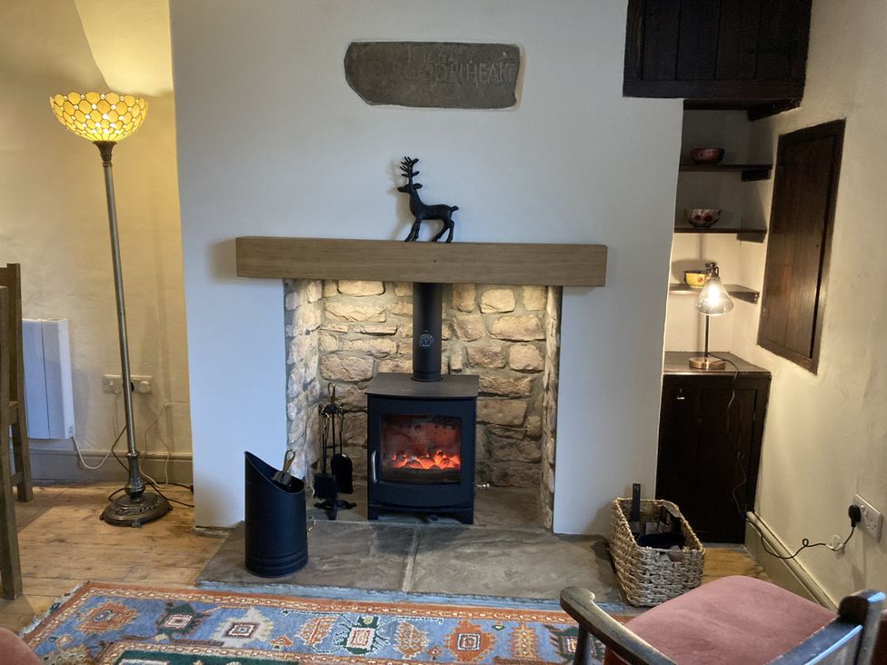 A living room with a fireplace and a lamp at 56 The Green Richmond