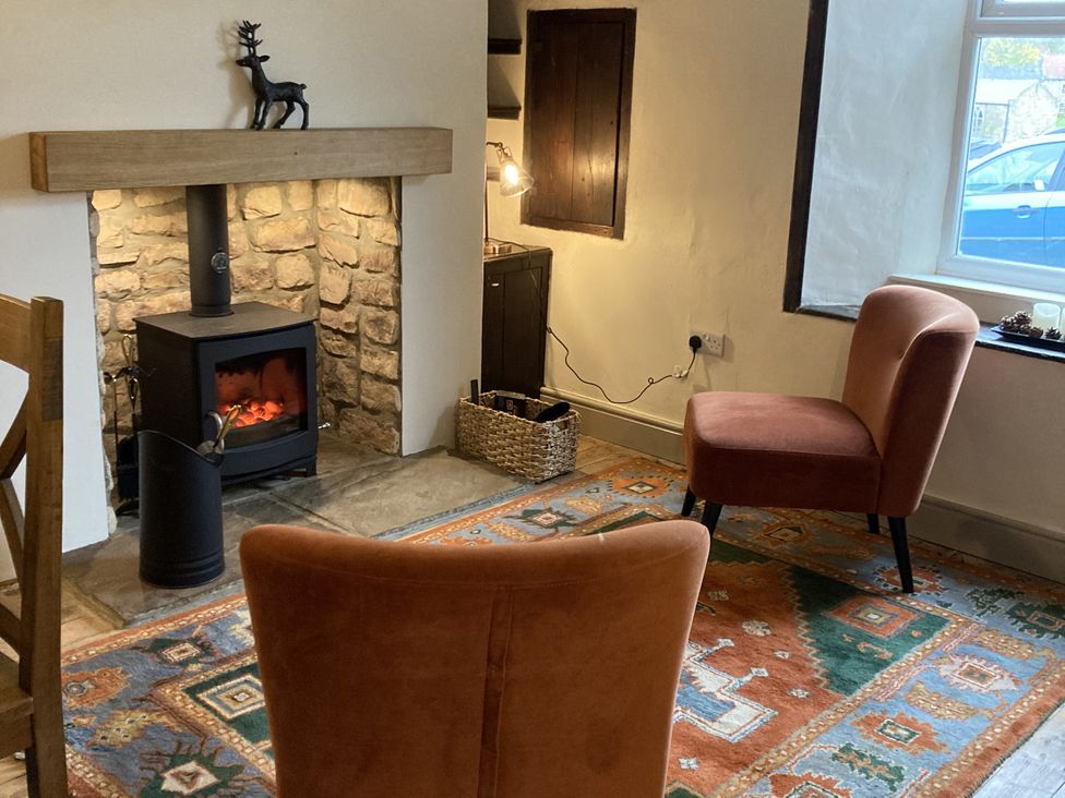A snug with a fireplace and two chairs at 56 The Green Richmond
