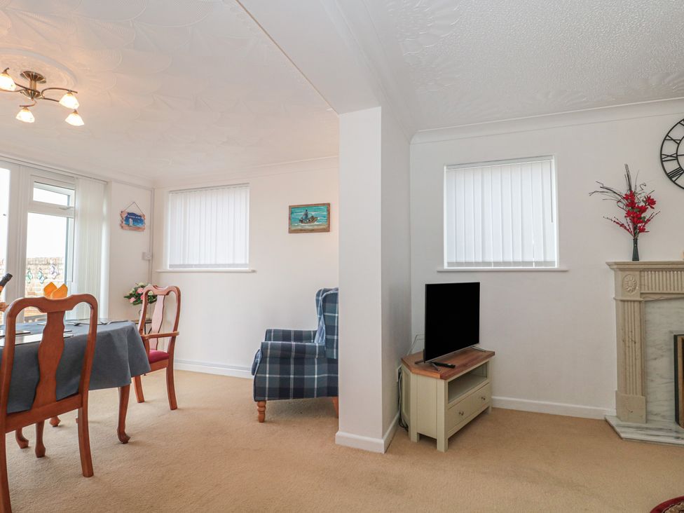 A living room with a table and chairs at Breaking Waves in Burnham-On-Sea