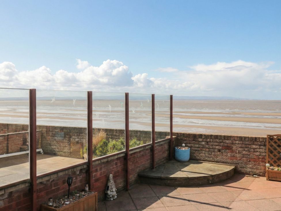 An outdoor space with a glass railing and view of the beach at Breaking Waves in Burnham-On-Sea