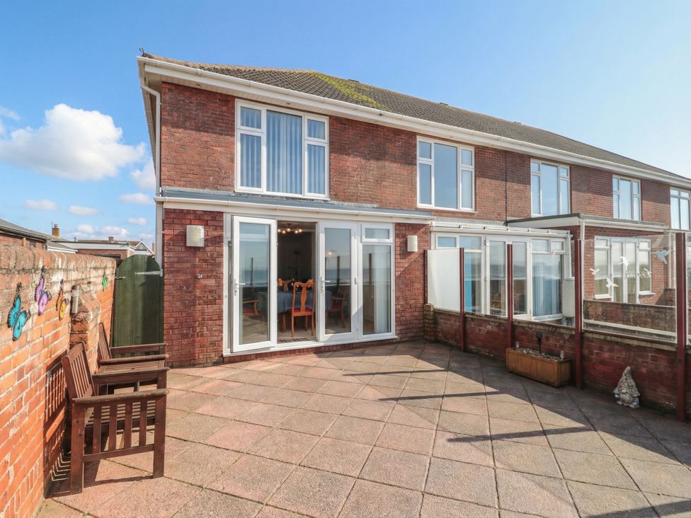 An outdoor area of a house with patio and furniture at Breaking Waves in Burnham-On-Sea