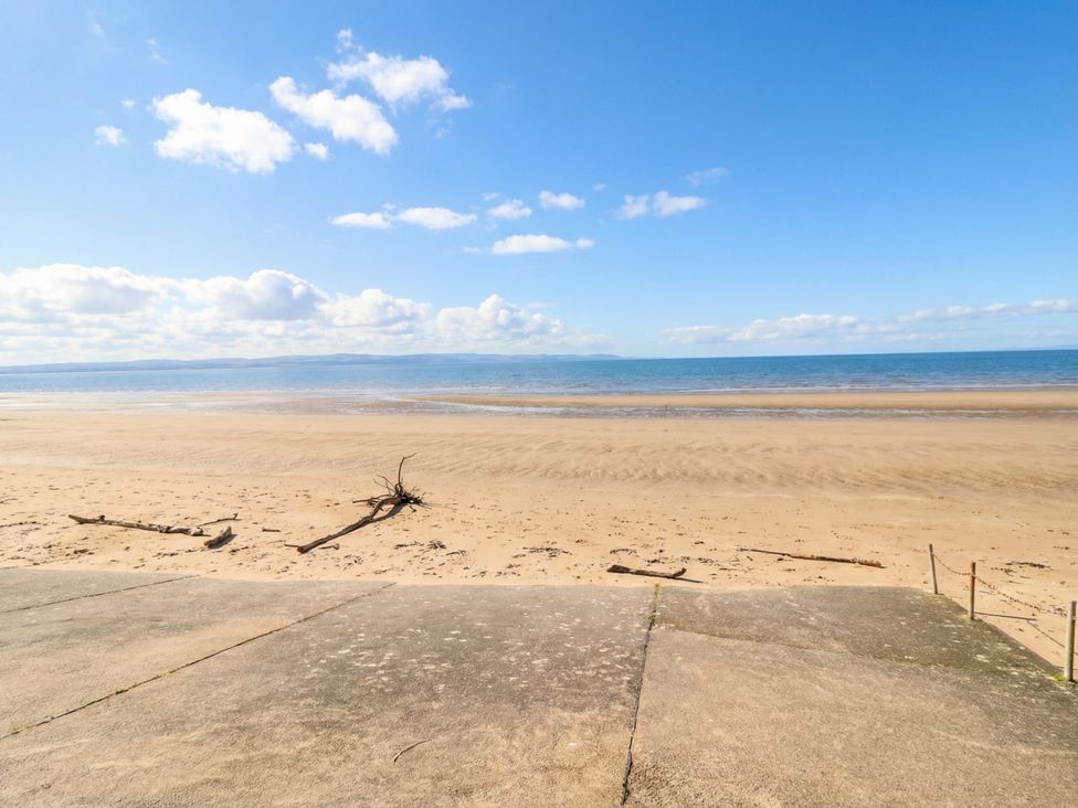 A beach with sand and water at Breaking Waves in Burnham-On-Sea