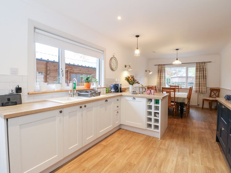 A kitchen with a sink and dining area at Beechwood Cottage in Blair Atholl