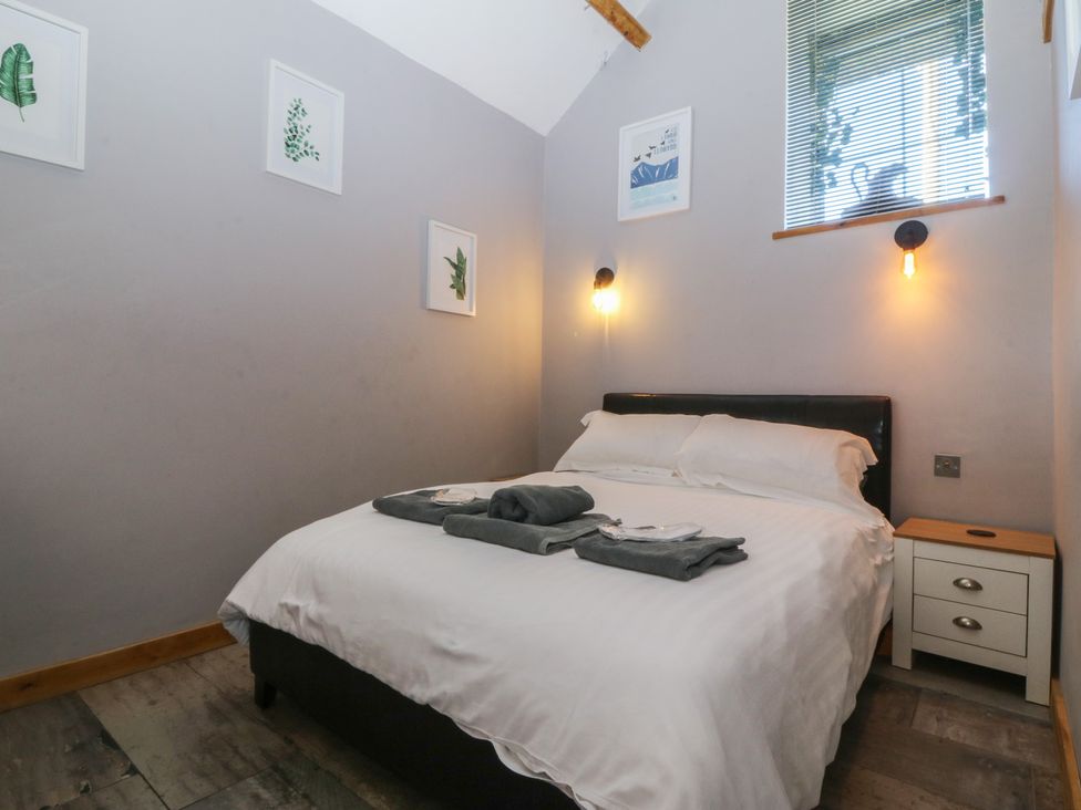 A bedroom with a bed and bedside table at Ty Coch in Llanaelhaearn near Trefor, Caernarfon