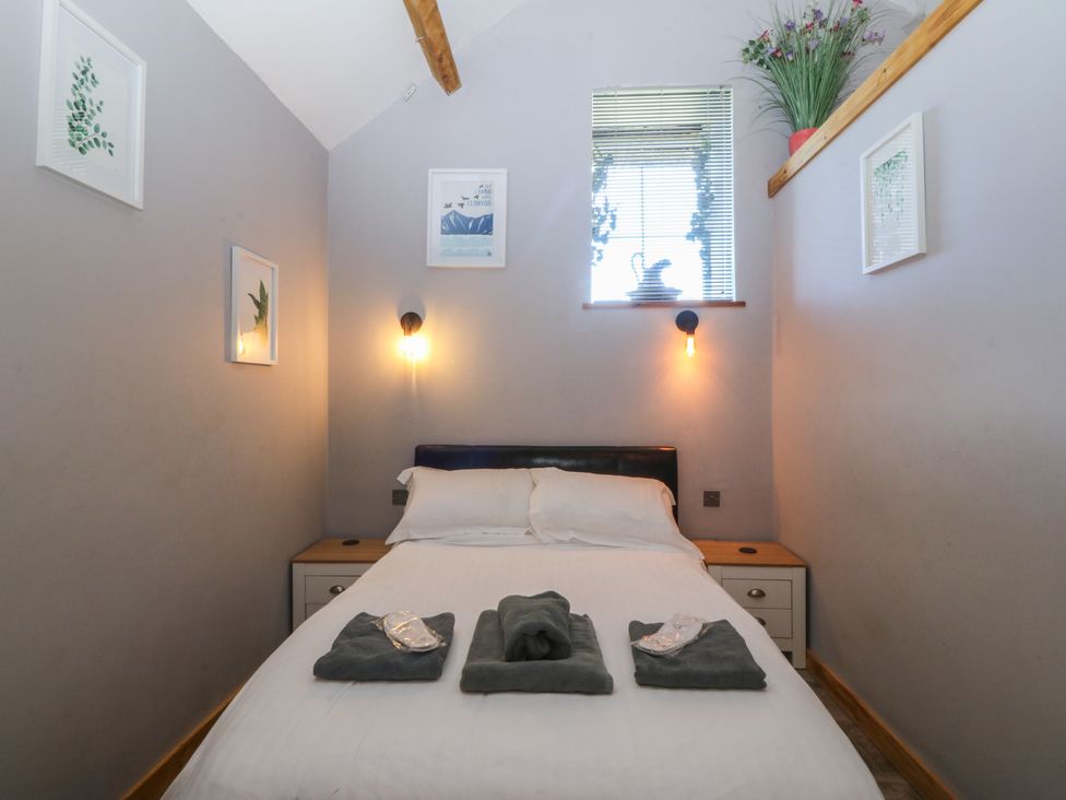A bedroom with a bed and towels on it at Ty Coch in Llanaelhaearn near Trefor, Caernarfon