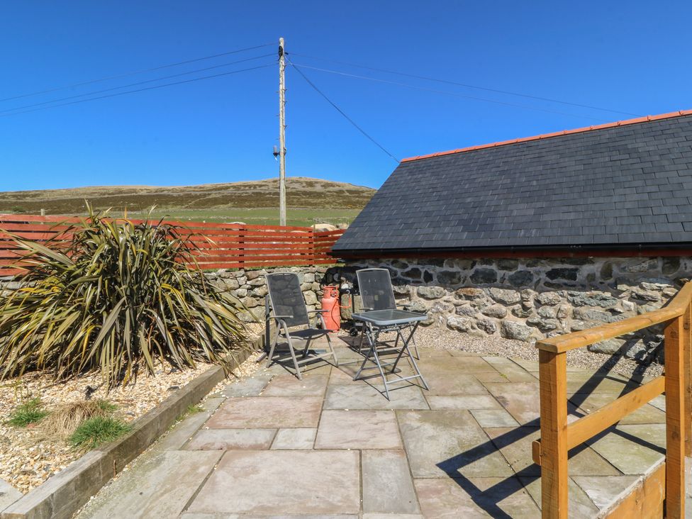An outdoor seating area with chairs and a table at Ty Coch in Llanaelhaearn near Trefor, Caernarfon