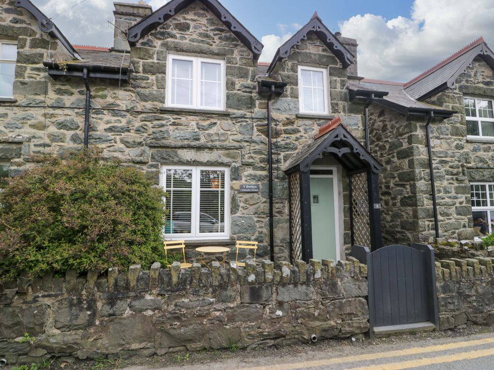 An exterior view of a stone house with a garden area at Y Bwthyn in Llanbedr