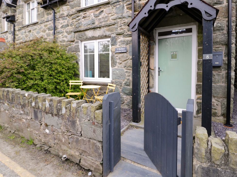 An outdoor area with a gate and bistro seating at Y Bwthyn in Llanbedr