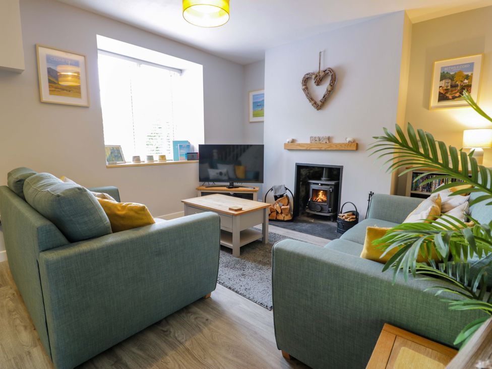 A living room with a television and a fireplace at Y Bwthyn in Llanbedr