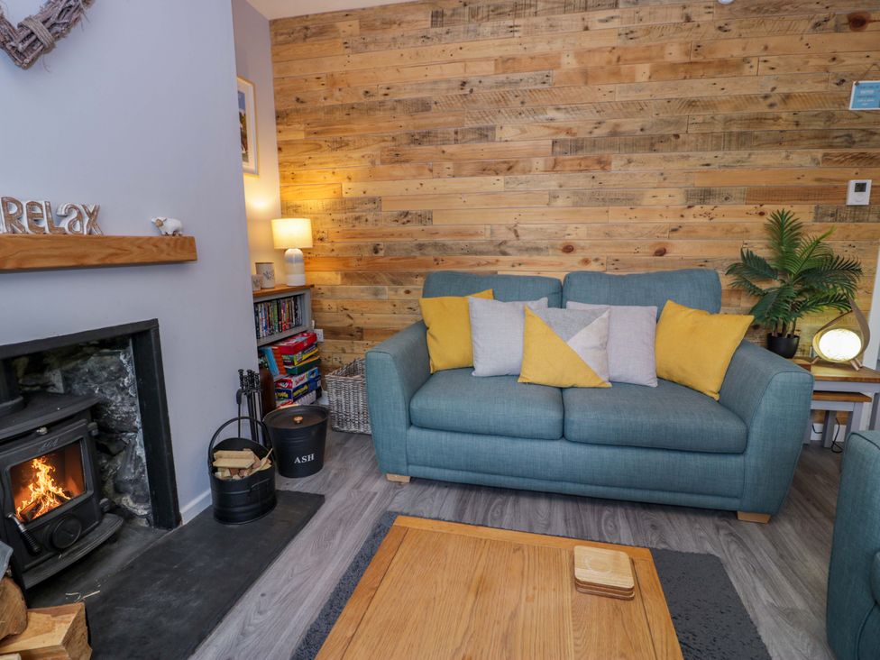 A living room with a sofa and fireplace at Y Bwthyn in Llanbedr