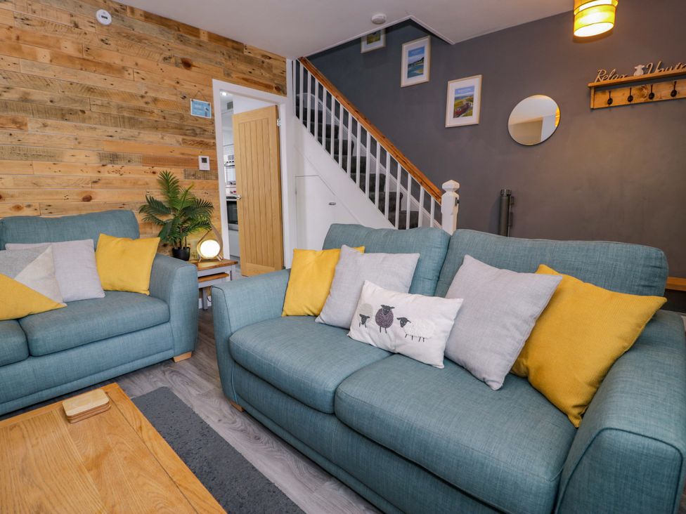 A living room with sofas and a staircase at Y Bwthyn in Llanbedr