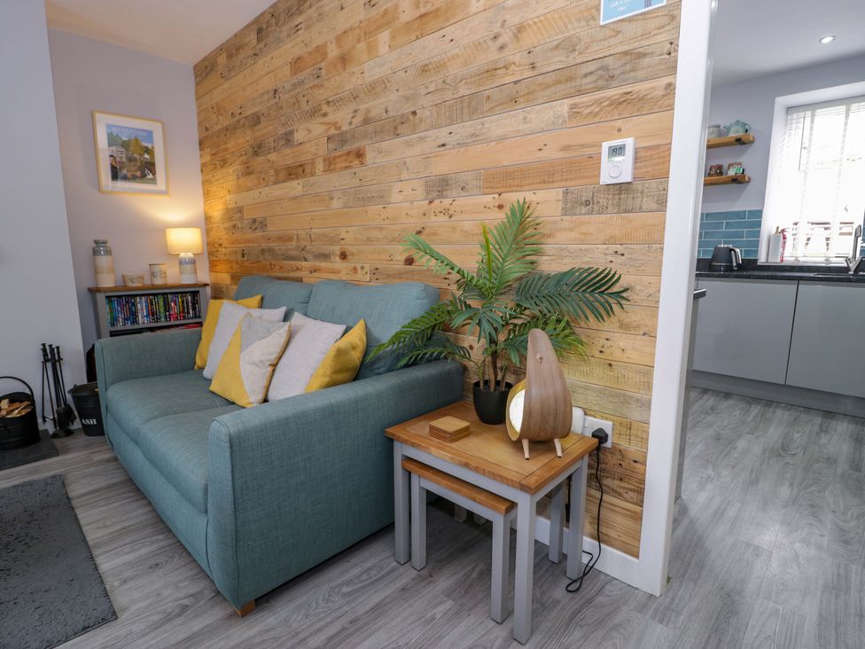 A living room with a sofa and side table at Y Bwthyn in Llanbedr