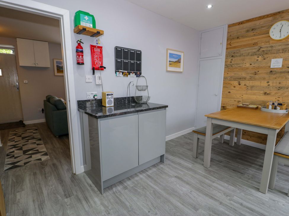 A kitchen with a table and chairs at Y Bwthyn in Llanbedr