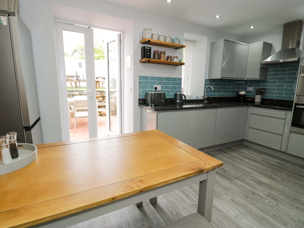 A kitchen with a table and chairs at Y Bwthyn in Llanbedr
