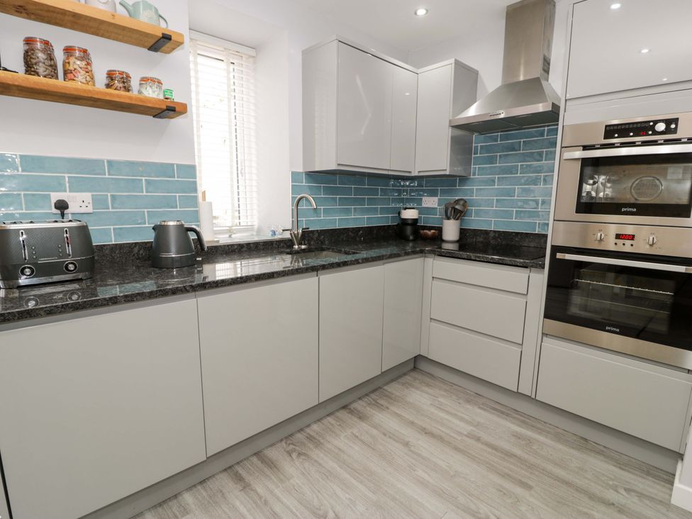 A kitchen with appliances and cabinets at Y Bwthyn in Llanbedr