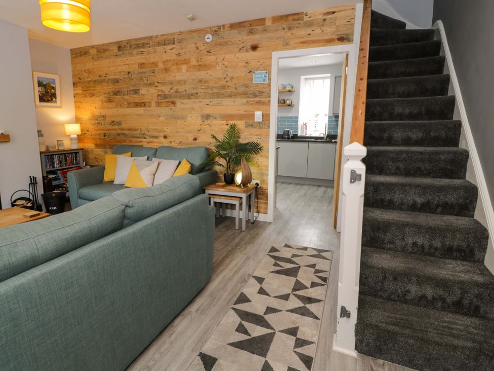 A living room with a sofa and lamp at Y Bwthyn in Llanbedr