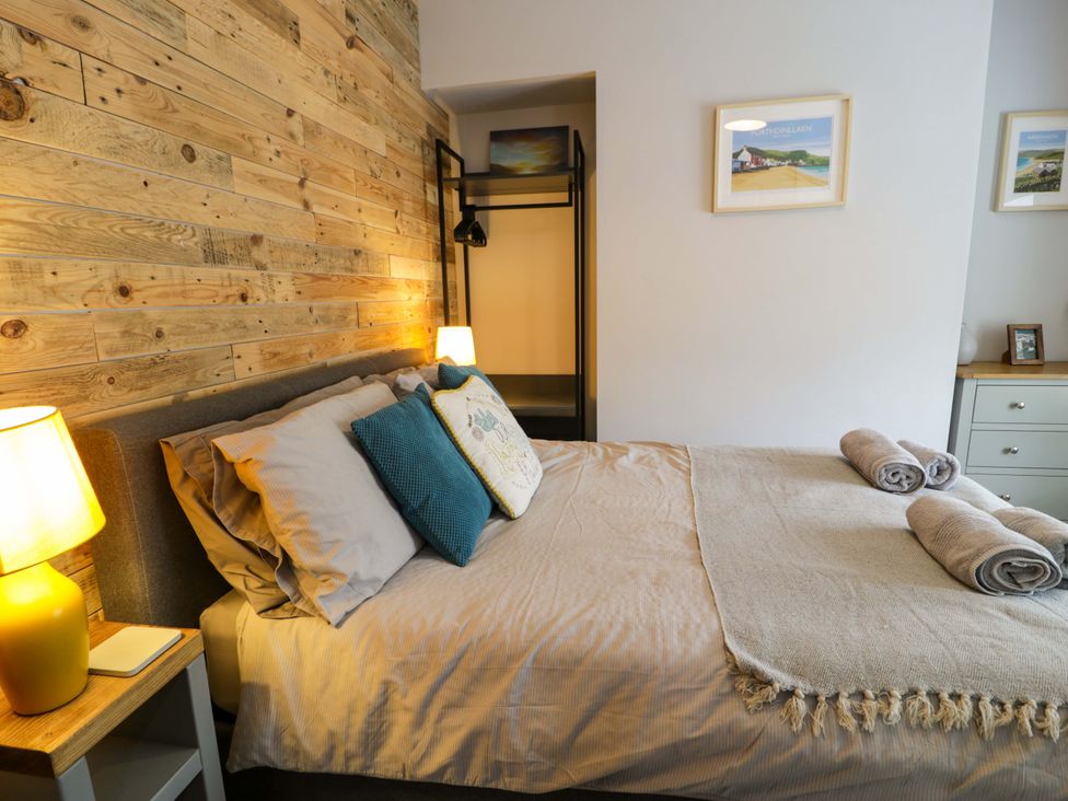 A bedroom with a bed and decorative items at Y Bwthyn in Llanbedr