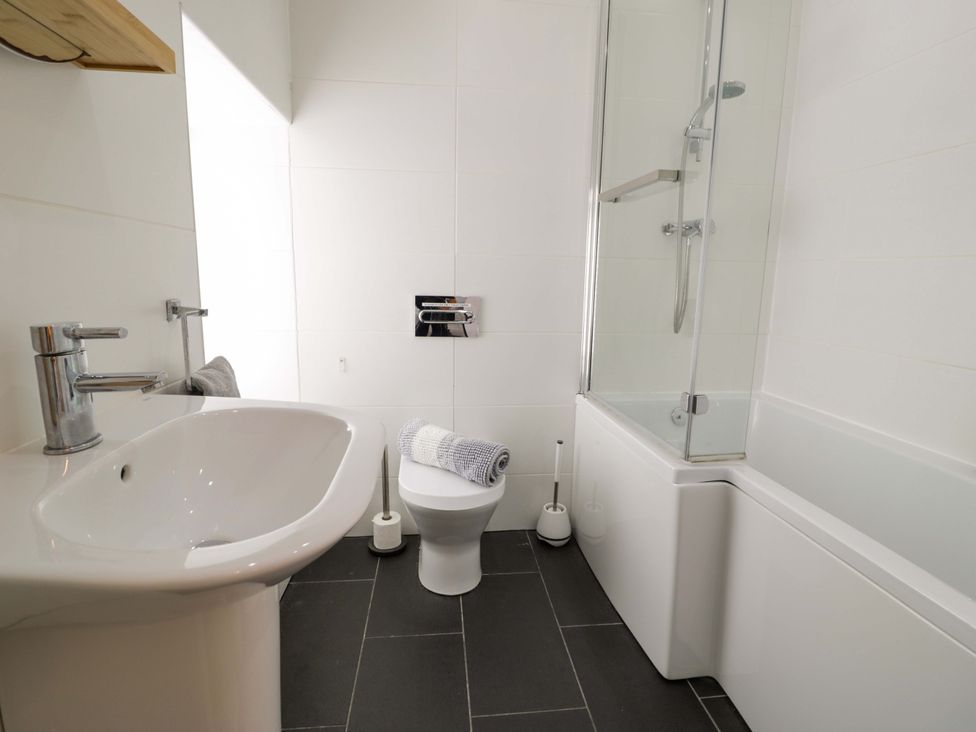 A bathroom with sink, toilet, and bathtub at Y Bwthyn in Llanbedr