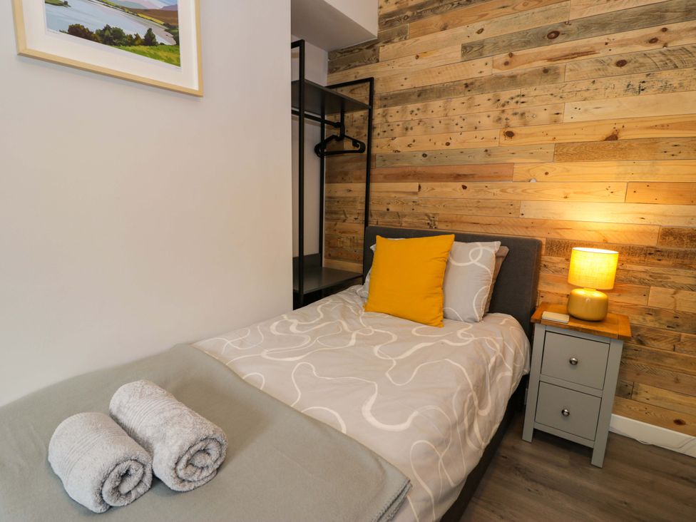 A bedroom with a bed and nightstand at Y Bwthyn in Llanbedr