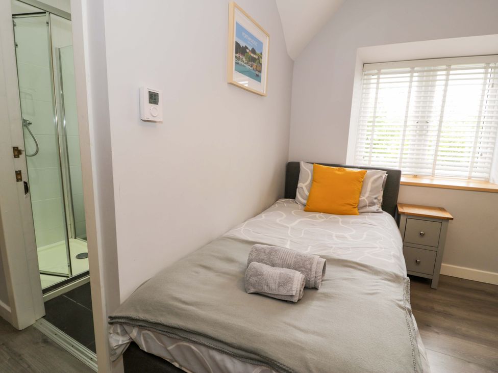 A bedroom with a bed and a shower at Y Bwthyn in Llanbedr