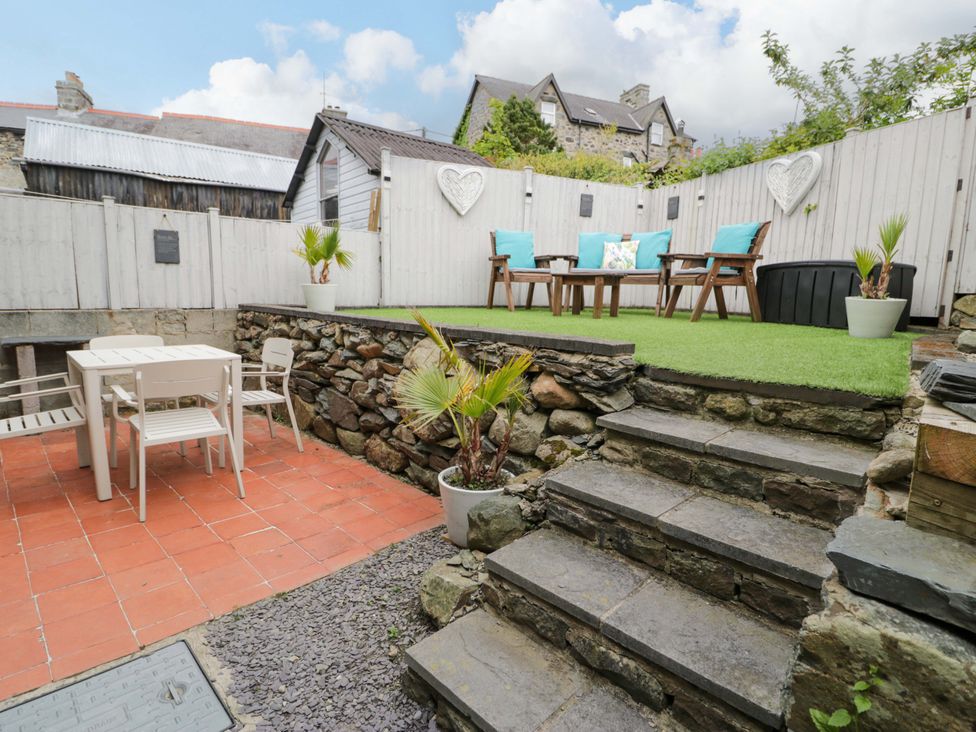 A garden with seating area and table at Y Bwthyn in Llanbedr