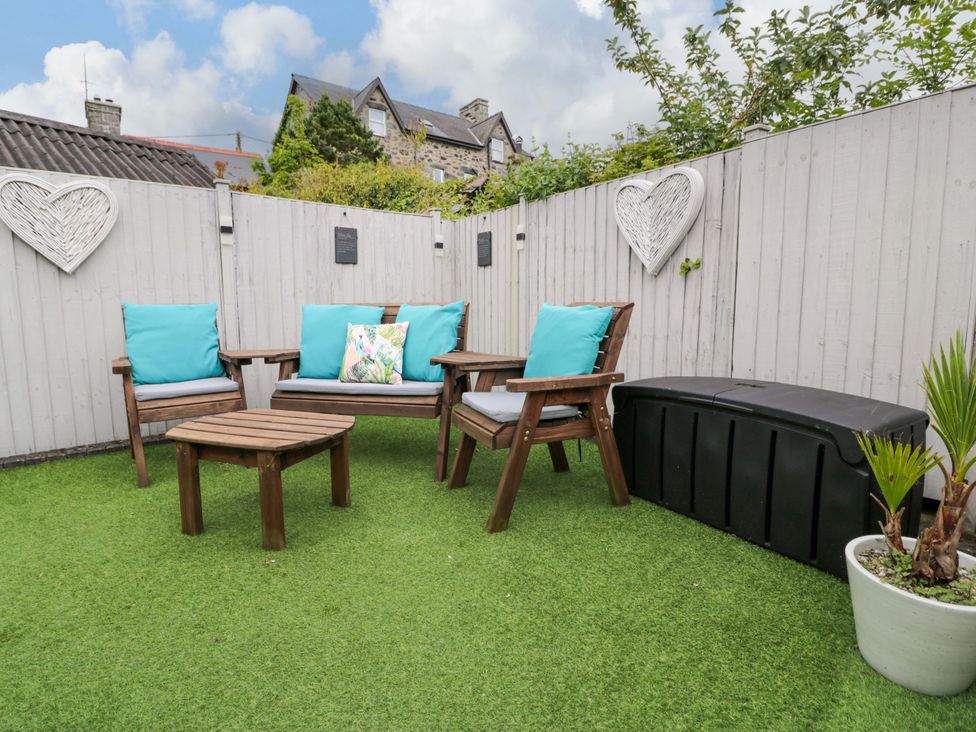 A garden with seating area and artificial grass at Y Bwthyn in Llanbedr